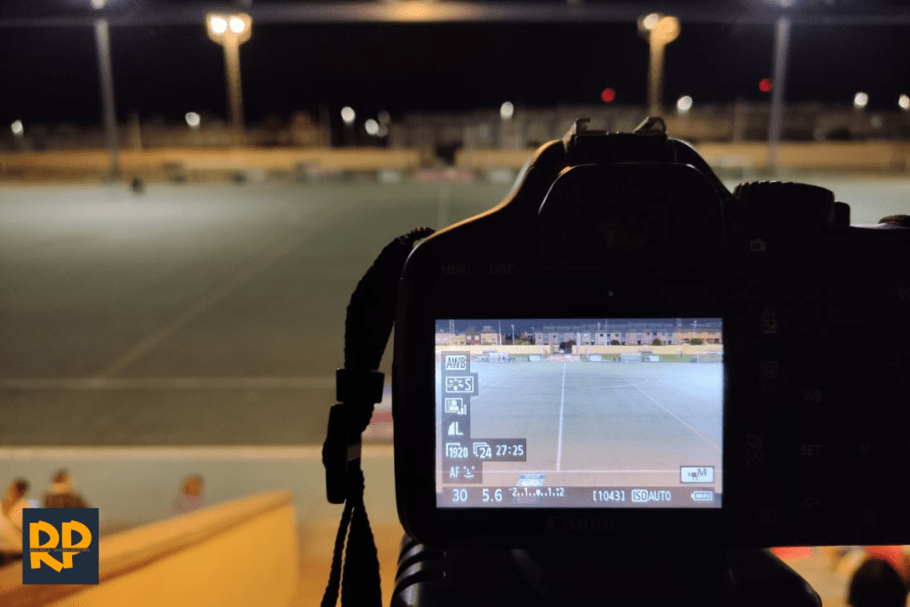 Foto del artículo sobre analistas de fútbol. Una cámara enfocando un campo antes de grabar un partido.